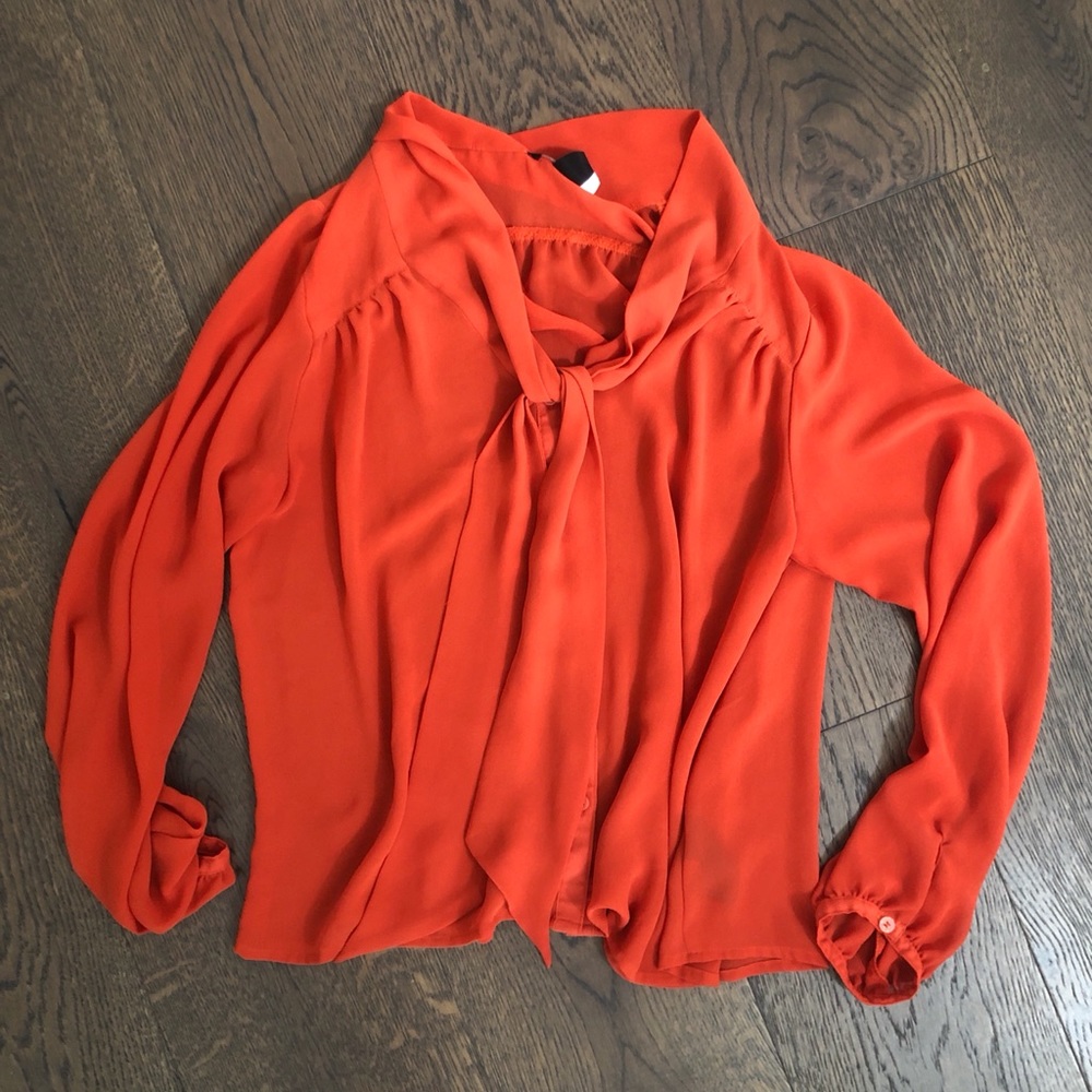 Blouse with bow detail around neck.